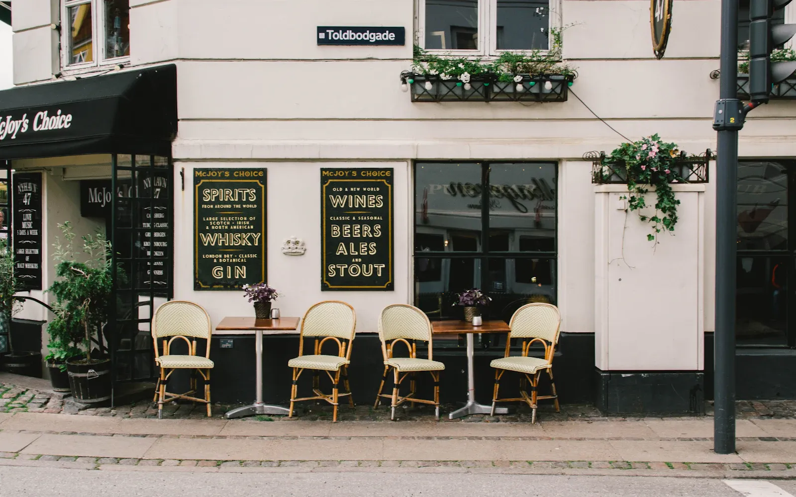 Lille café med borde og stole foran facaden