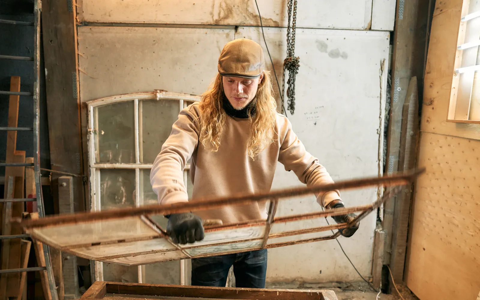 Kvinde der arbejder med et møbel i sit værksted
